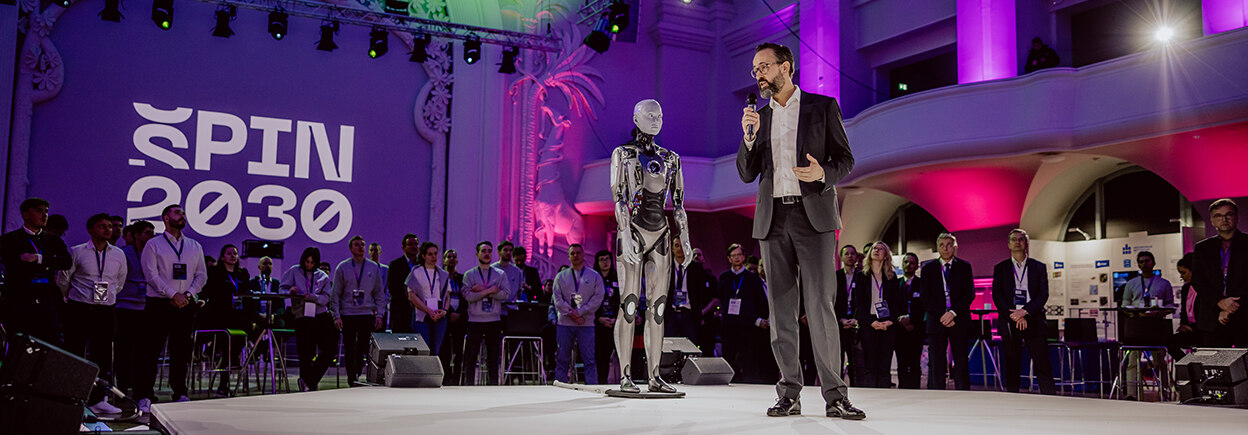 Wissenschaftsminister Sebastian Gemkow auf der Bühne bei der Eröffnungsveranstaltung für SPIN2030. Link zur Startseite der Kampagne SPIN2030